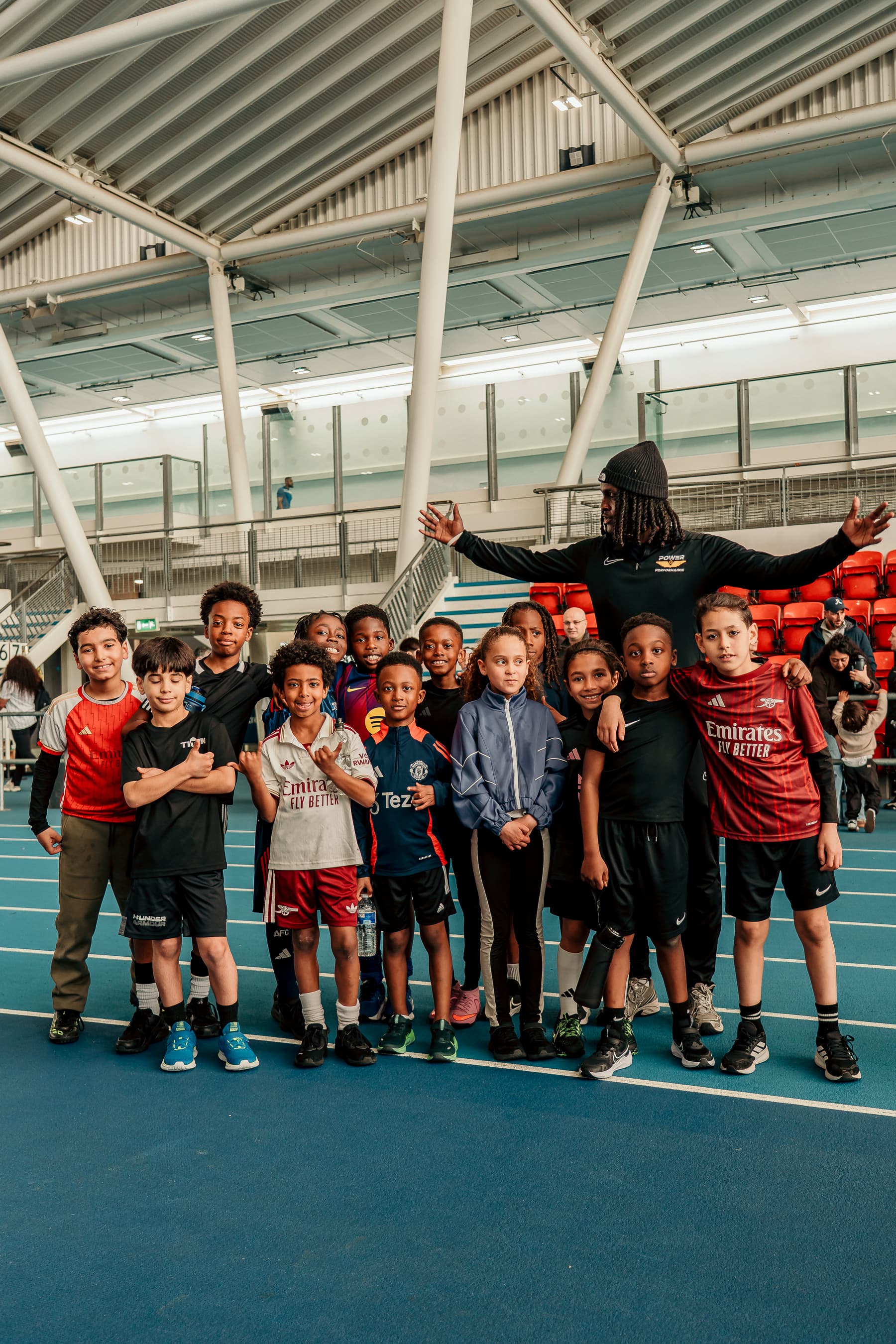 Coach speaking with young athletes on a training track